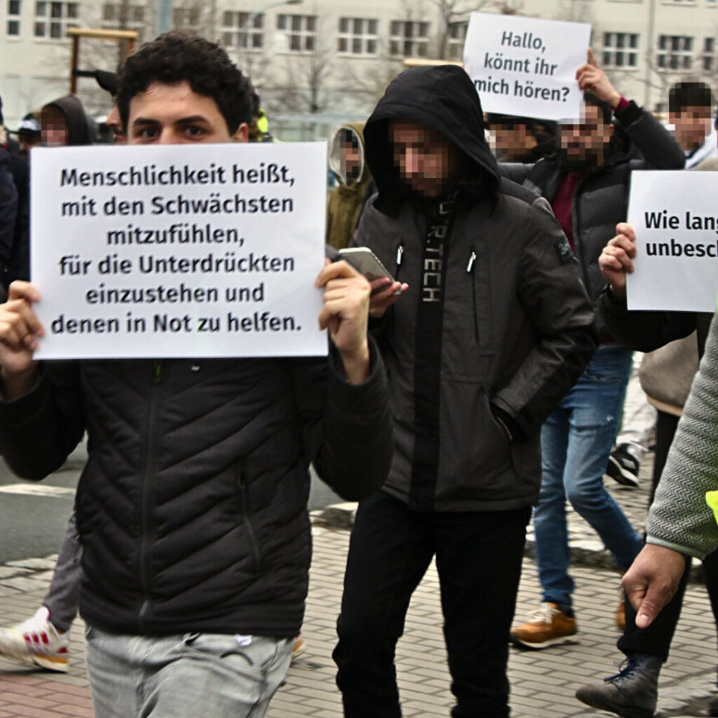 Bewohner demonstrieren in Hermsdorf. Schild "Menschlichkeit heißt, mit den Schwächsten mitzufühlen, für die Unterdrückten einzustehen und denen in Not zu helfen."